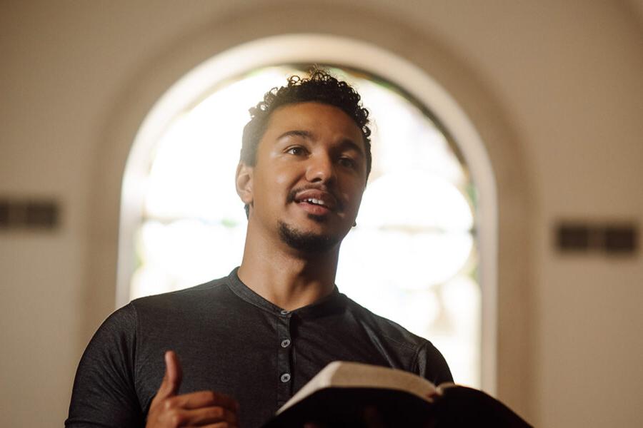 a PBA student holding a Bible while standing in the chapel